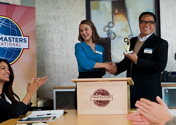 A Toastmaster receiving an award at a Toastmaster's meeting